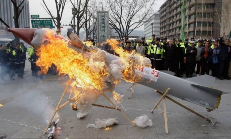 South Korean protesters burn a mockup of a North Korean missile during a protest against the North&#039;s failed long-range rocket launch.