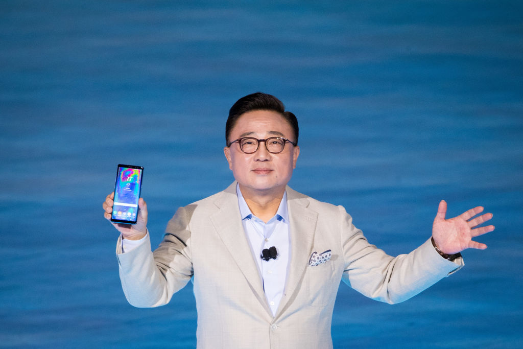 President of Samsung holds up new Galaxy Note 8 smartphone.