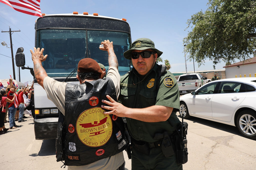 A protester tries to stop a bus carrying children separated from their parents
