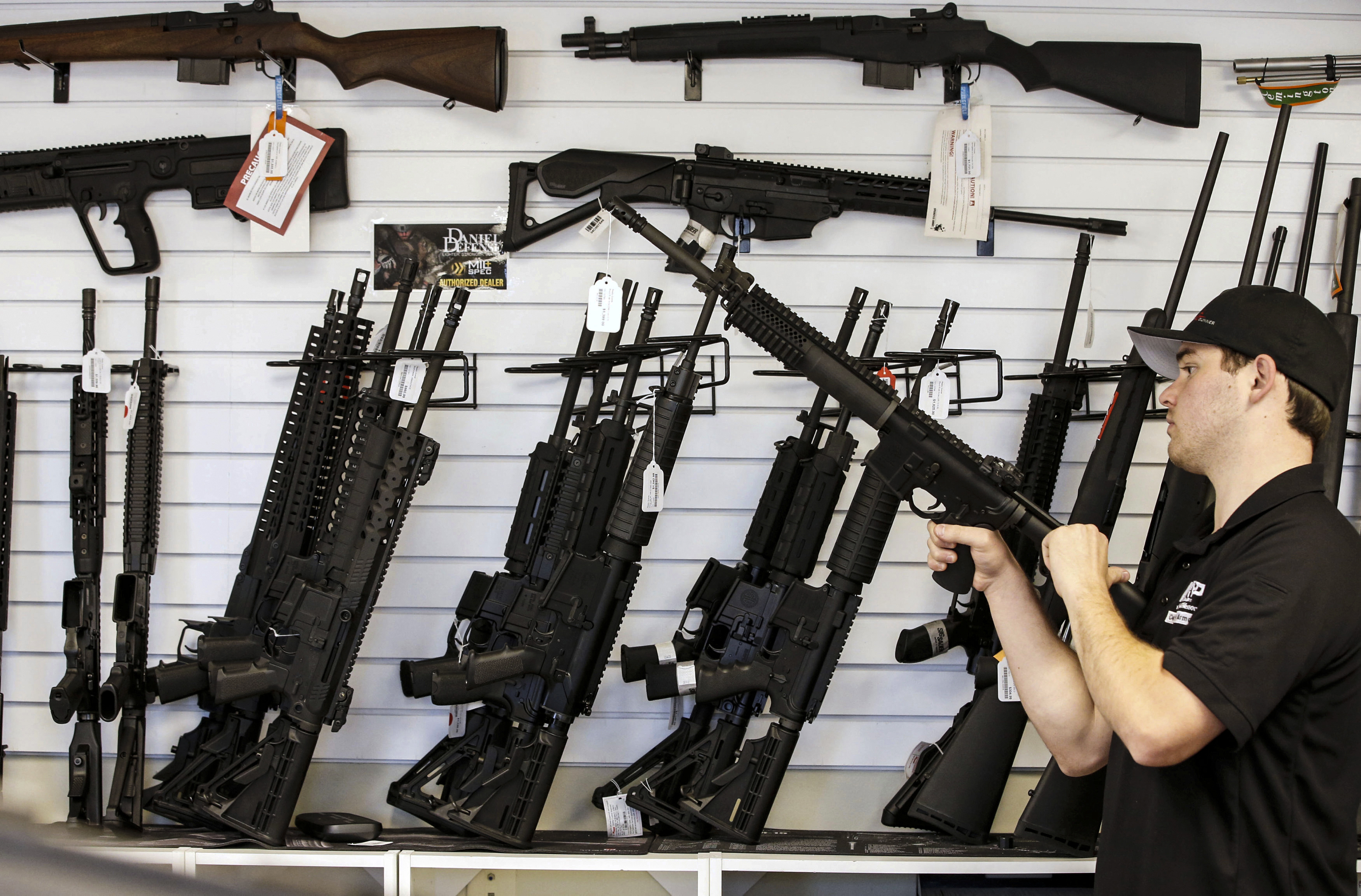 A salesman clears the chamber of an AR-15 at a gun store in Utah.