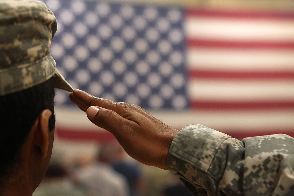 Soldier saluting American flag.