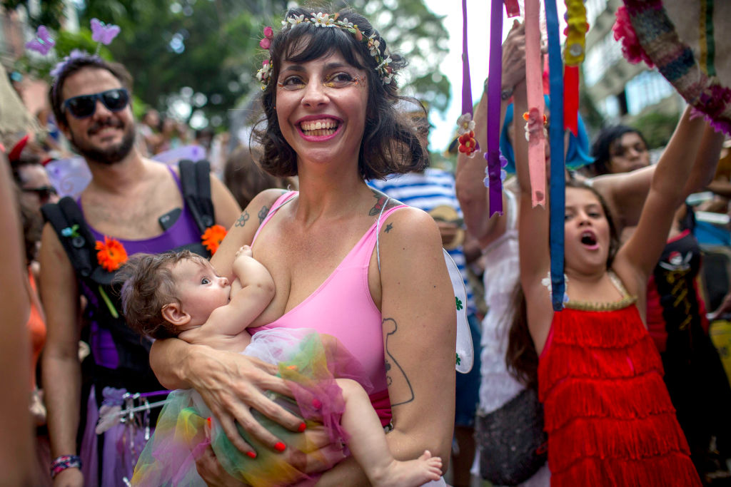 A mother breastfeeds during Carnival in Brazil