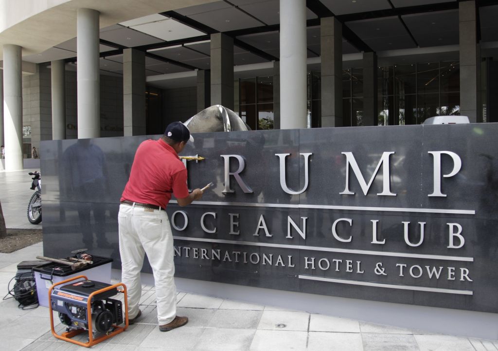 Worker removing Trump letters from hotel in Panama City.