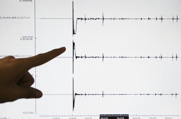 A person points to a seismograph.