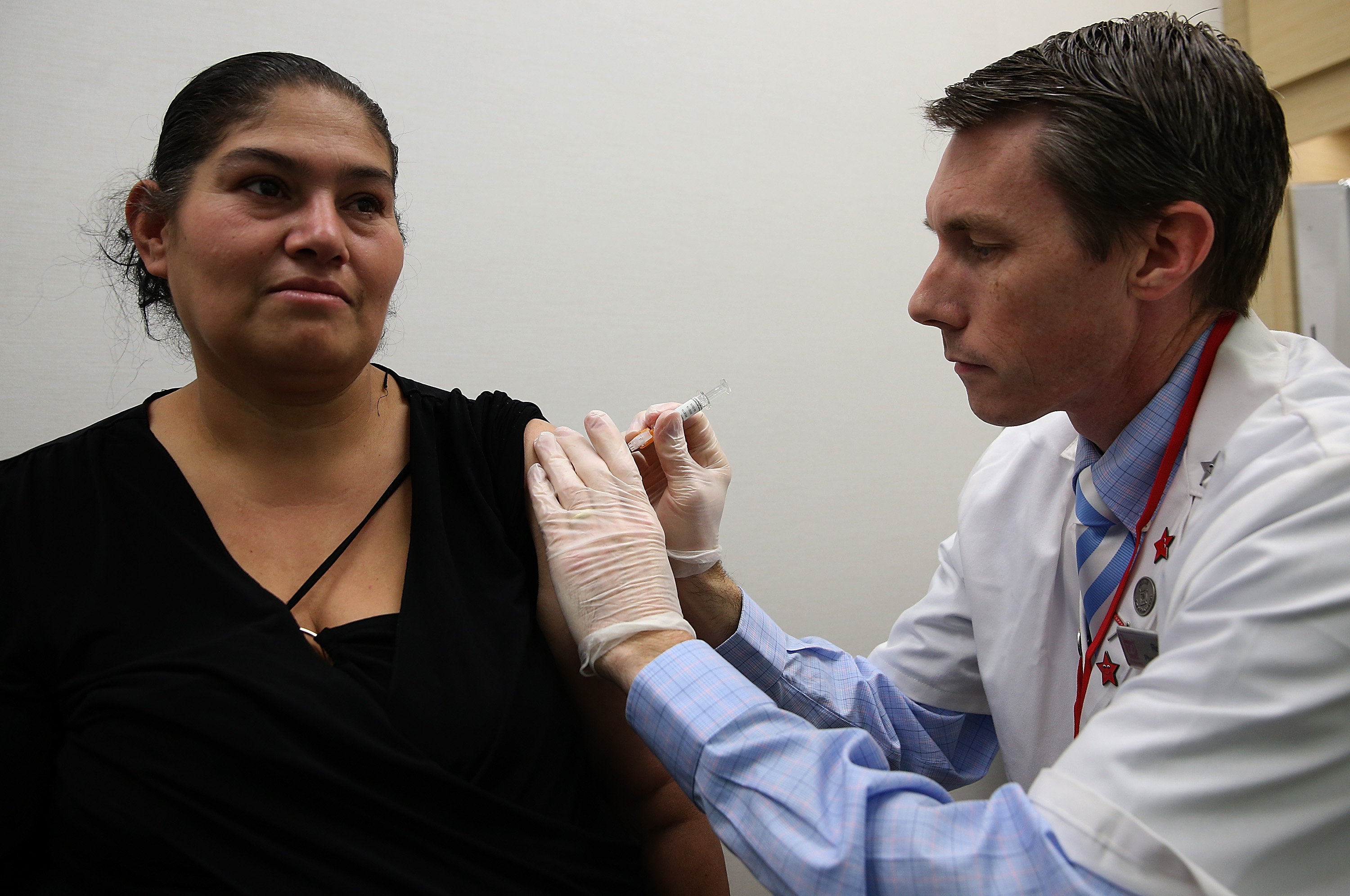 A doctor gives a woman a flu shot.