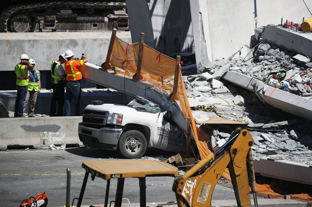 Members of the National Transportation Safety Board investigate the scene where a pedestrian bridge collapsed a few days after it was built over southwest 8th street allowing people to bypass