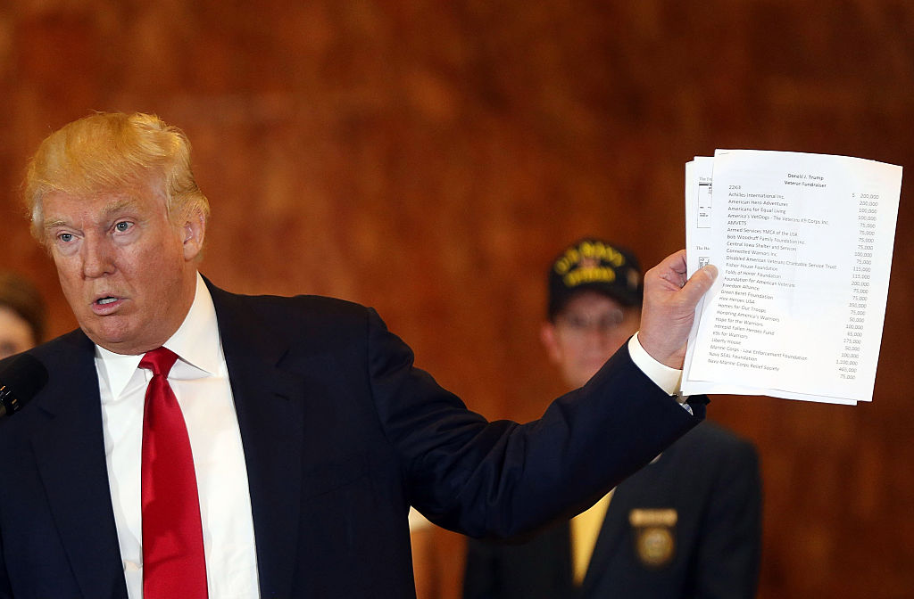 Donald Trump holds up papers.