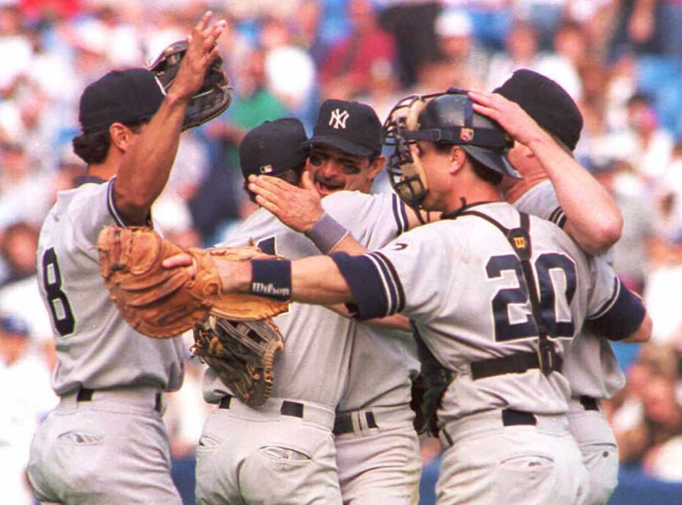 Don Mattingly (center) hugs his teammates after the New York Yankees beat the Toronto Blue Jays in the 1995 American League wild-card game. 