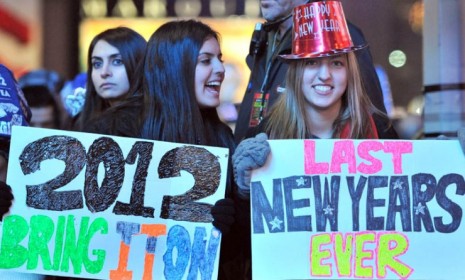 A New Year&#039;s eve reveler holds up a doomsday-inspired sign