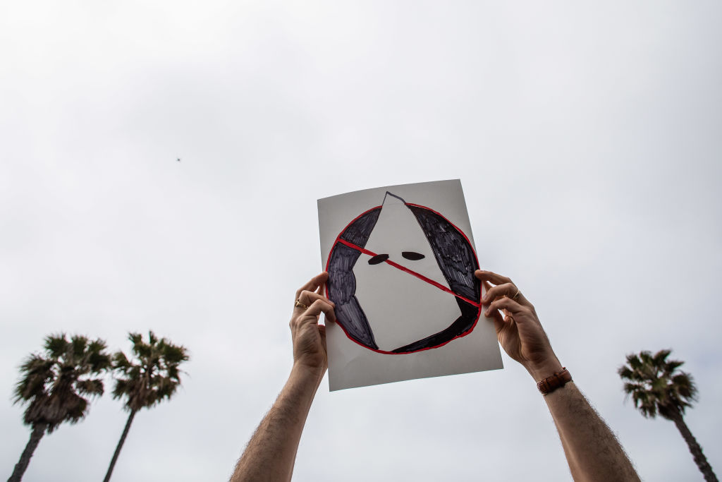 A person holds an anti-white supremacy sign in Huntington Beach, California.