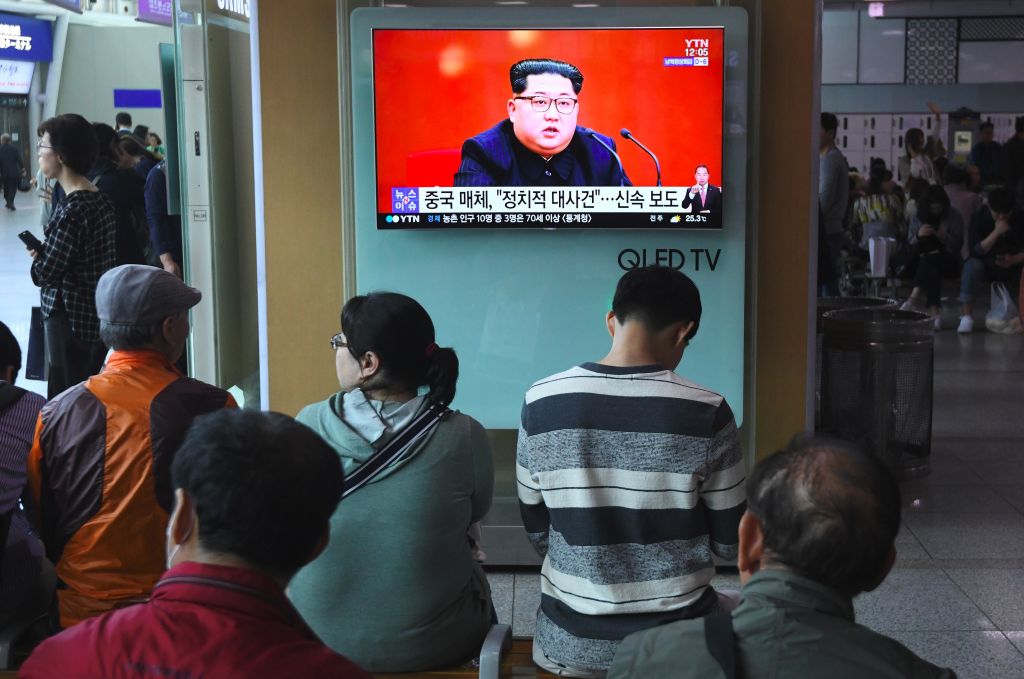 People watch a television news showing a file footage of North Korean leader Kim Jong Un, at a railway station in Seoul on April 21, 2018. 