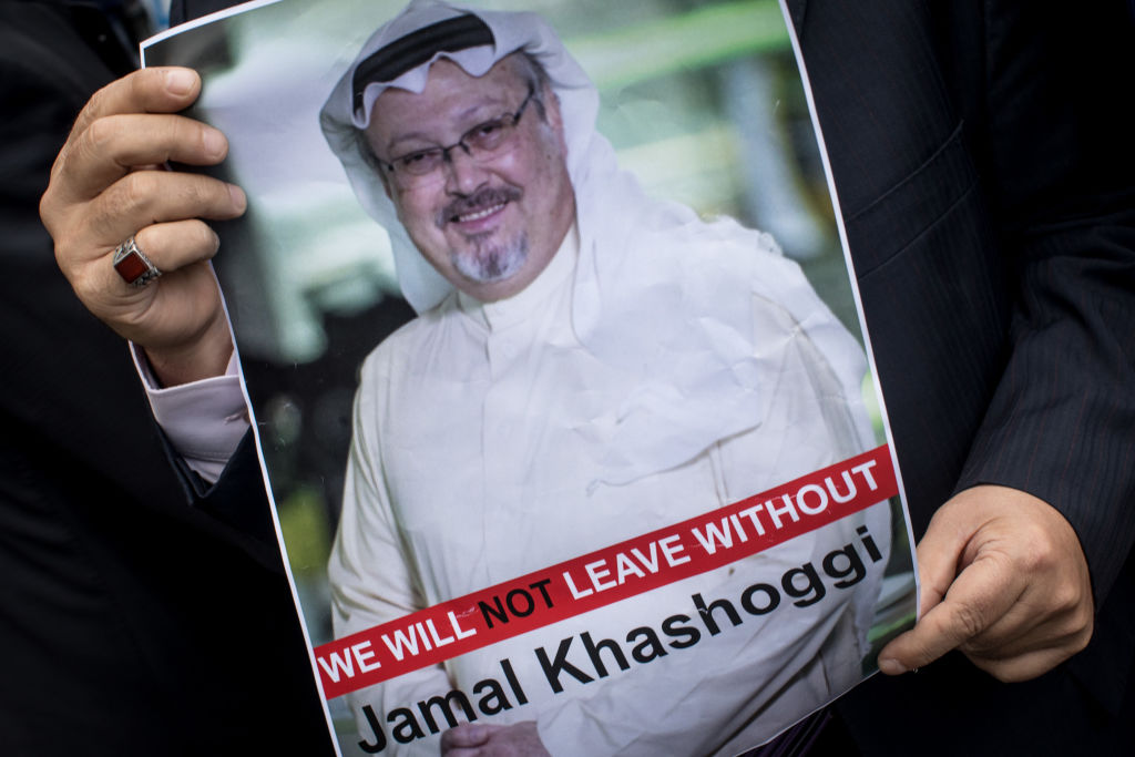 A protester holds a poster showing Jamal Khashoggi.