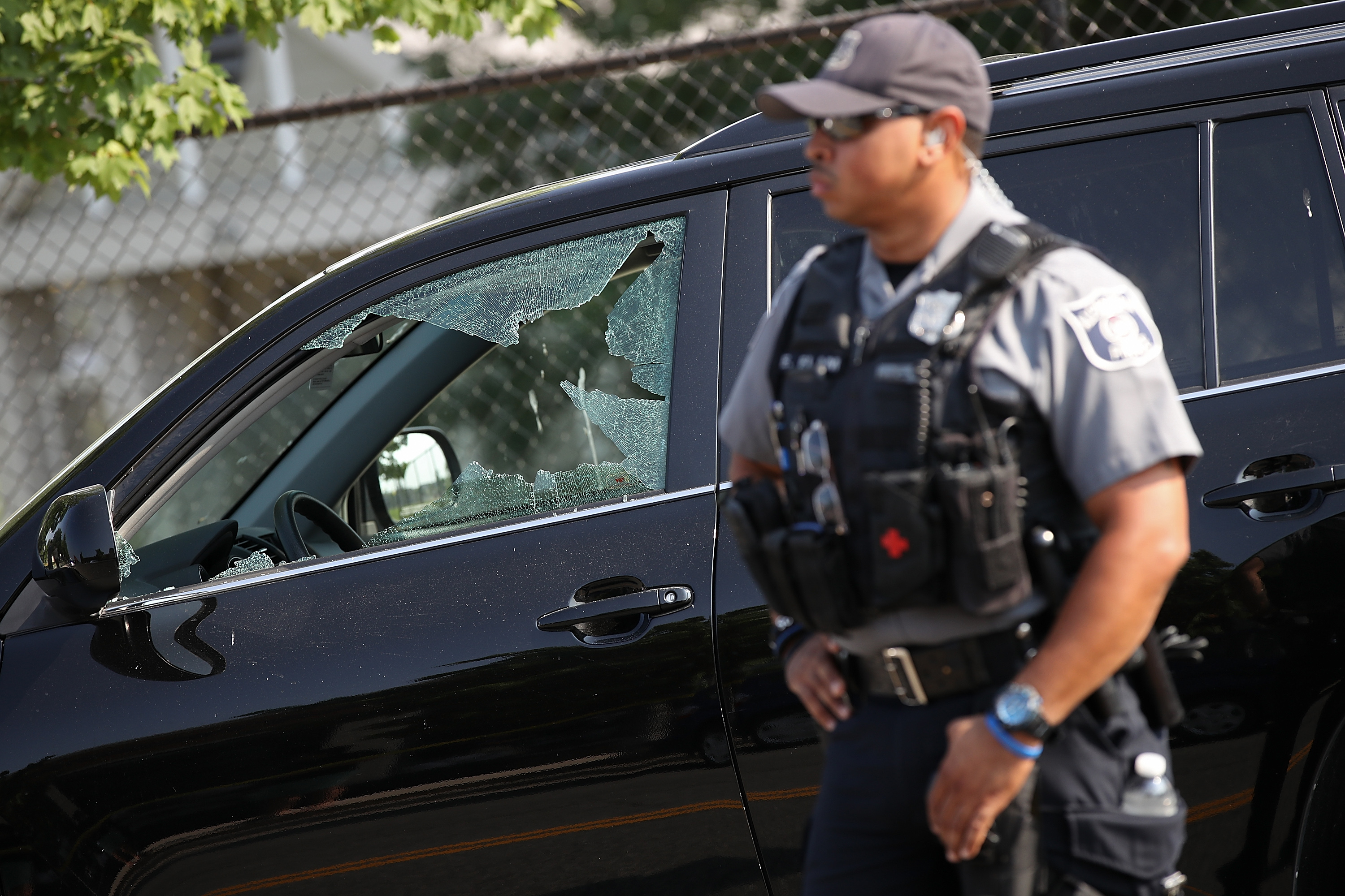 The shattered window of a vehicle hit by a bullet.
