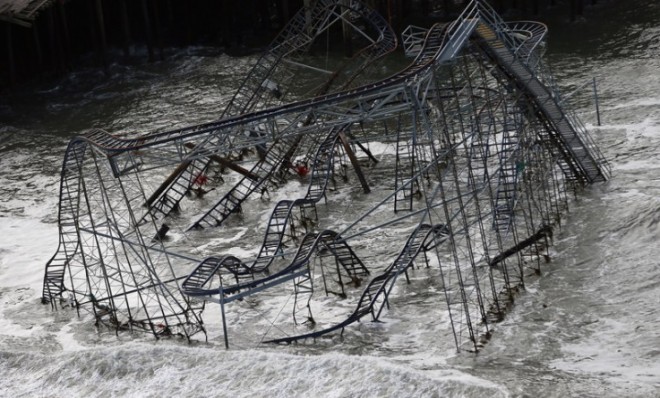 Surf rolls past a destroyed roller coaster wrecked by Superstorm Sandy in Seaside Heights, New Jersey.