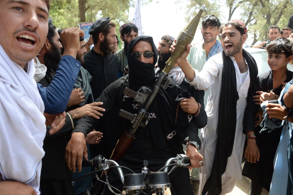 An Afghan Taliban militants carries a rocket-propelled as he looks on with residents as they took to the street to celebrate ceasefire on the second day of Eid in the outskirts of Jalalabad o