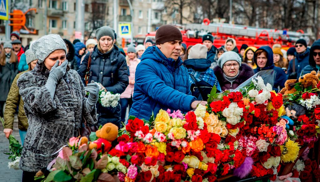 People leave flowers at a memorial to the Siberian fire victims.