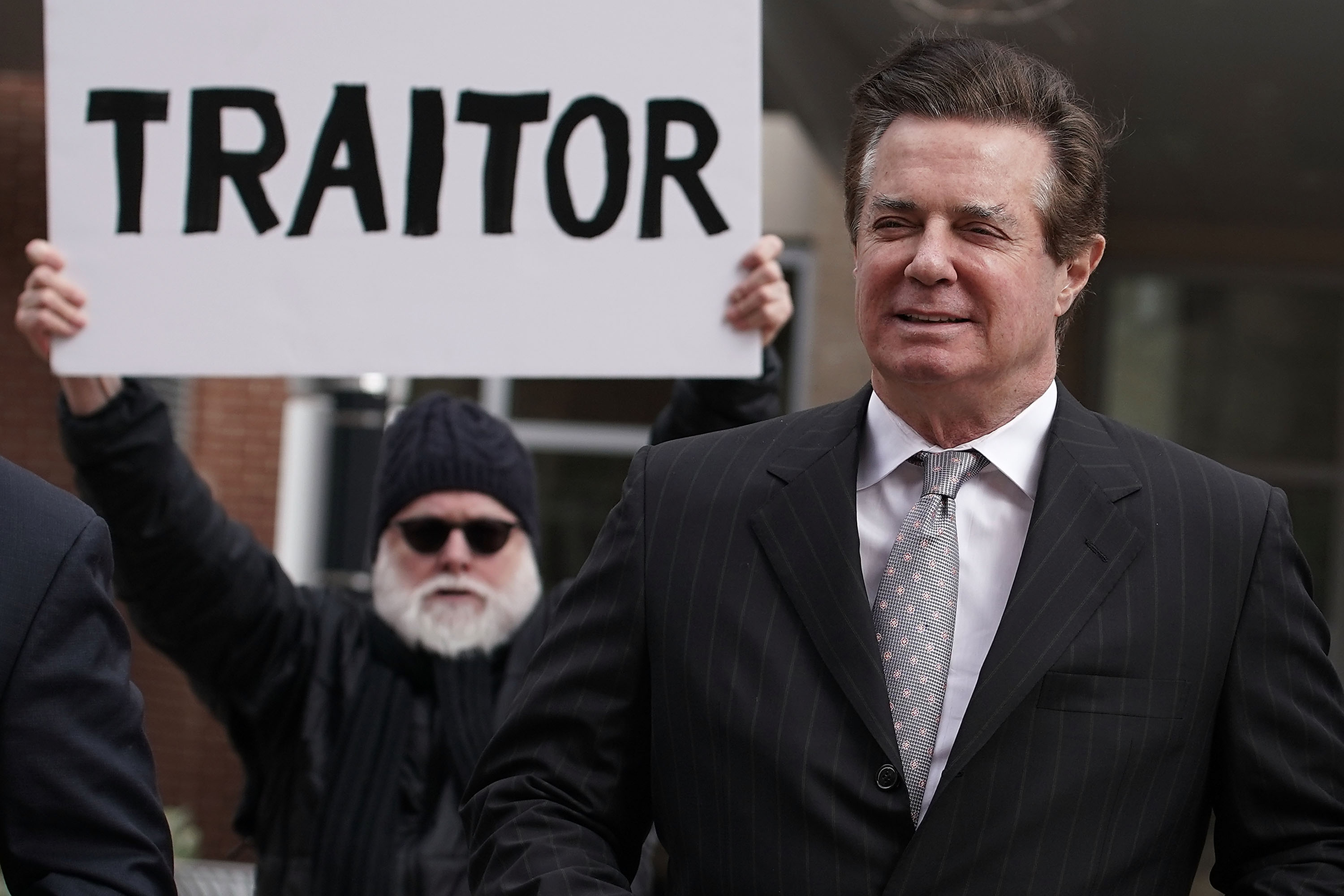 Paul Manafort is greeted by a protester.