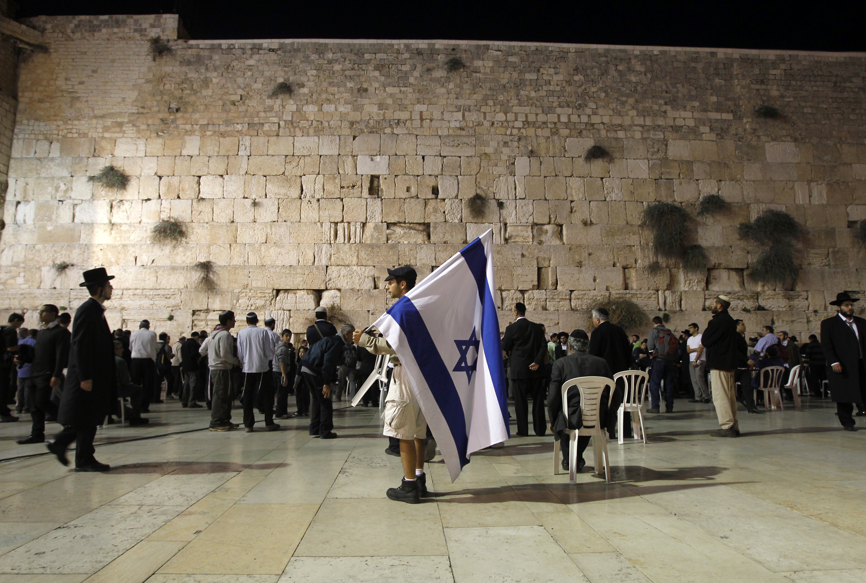 A man holds an Israeli flag during a mass prayer at the Western Wall in Jerusalem.