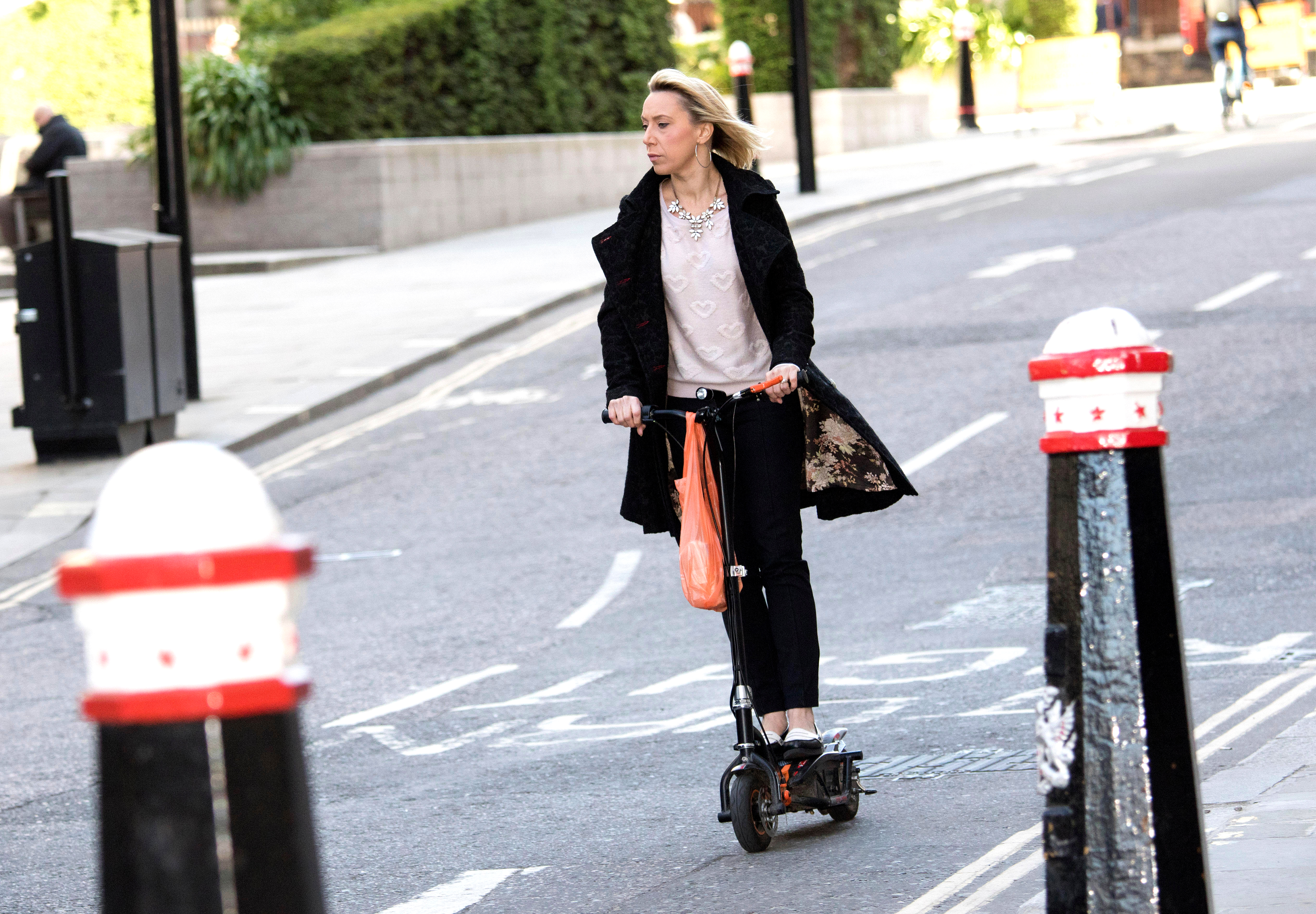 A woman riding an electric scooter.