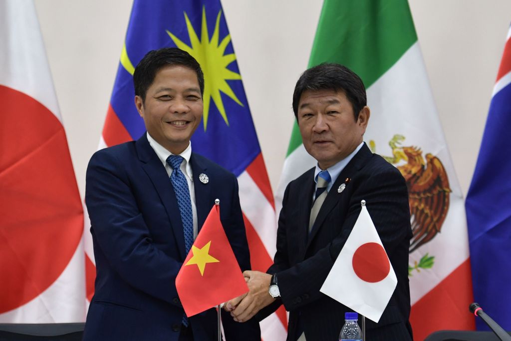 Vietnam&#039;s Trade Minister Tran Tuan Anh (L) shakes hands with Japan&#039;s Economic Revitalization Minister Toshimitsu Motegi (R) at the end of a Trans Pacific Partnership (TPP) press conference