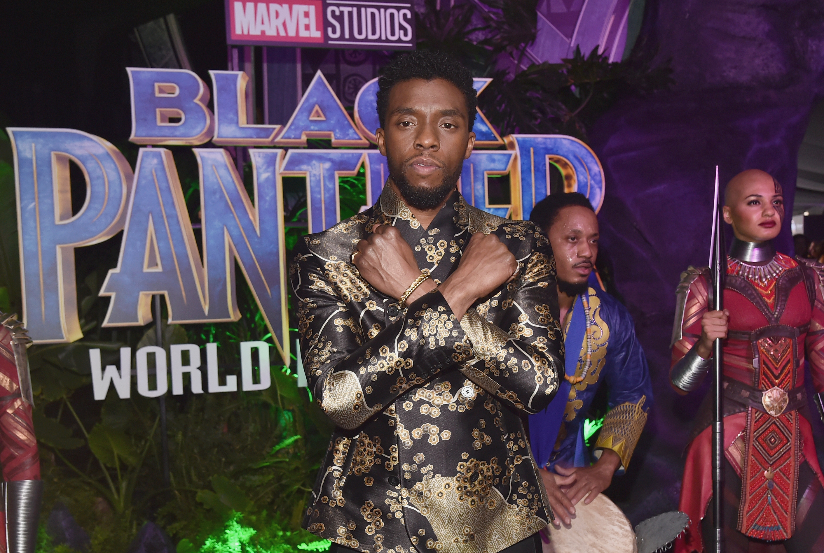 Chadwick Boseman in front of a Black Panther sign
