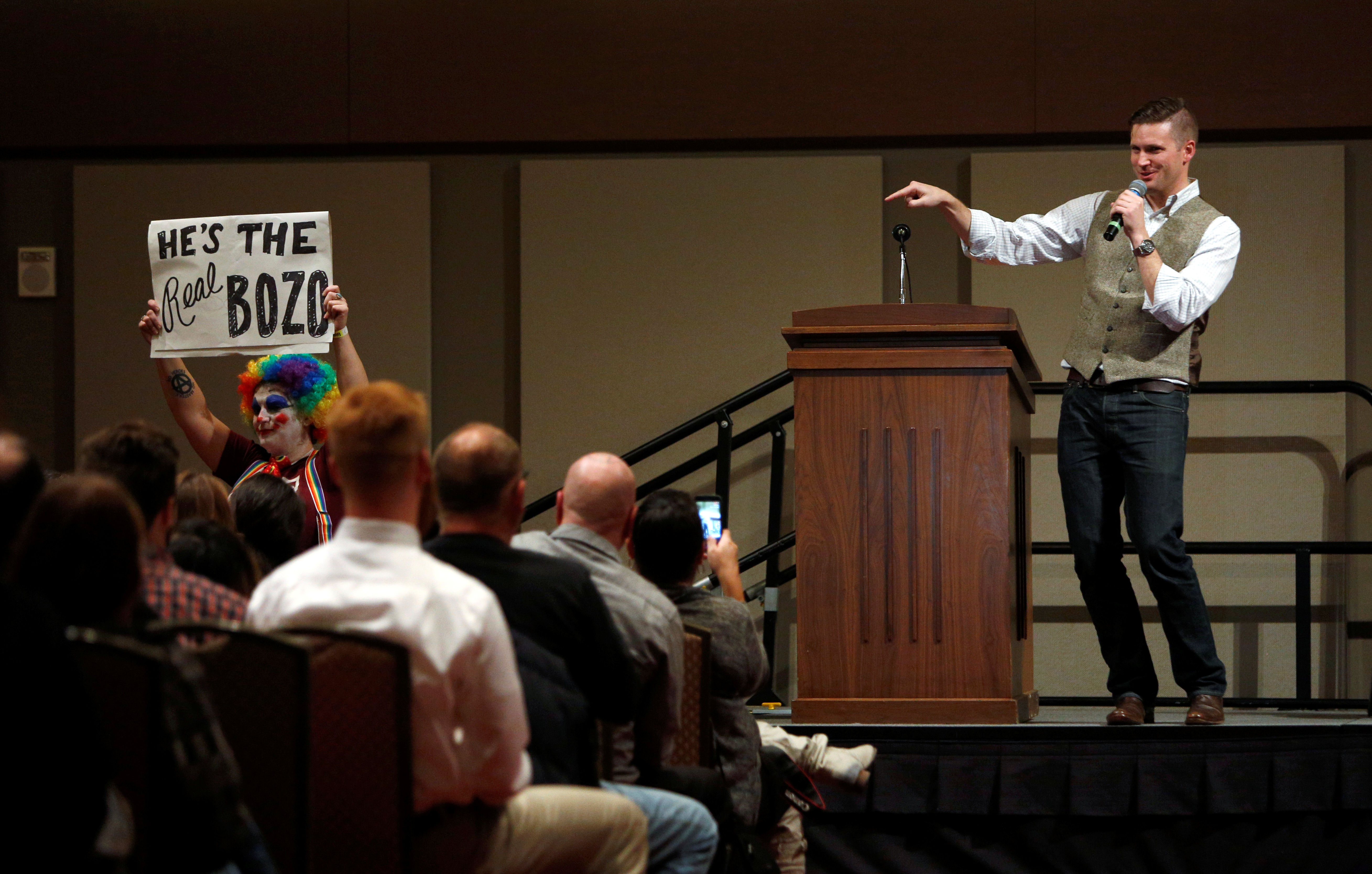 White nationalist leader Richard Spencer speaks on the Texas A&amp;M University campus as a silent protester holds a placard in College Station, Texas.