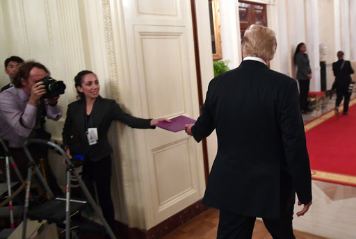 Epoch Times photojournalist hands Trump a folder