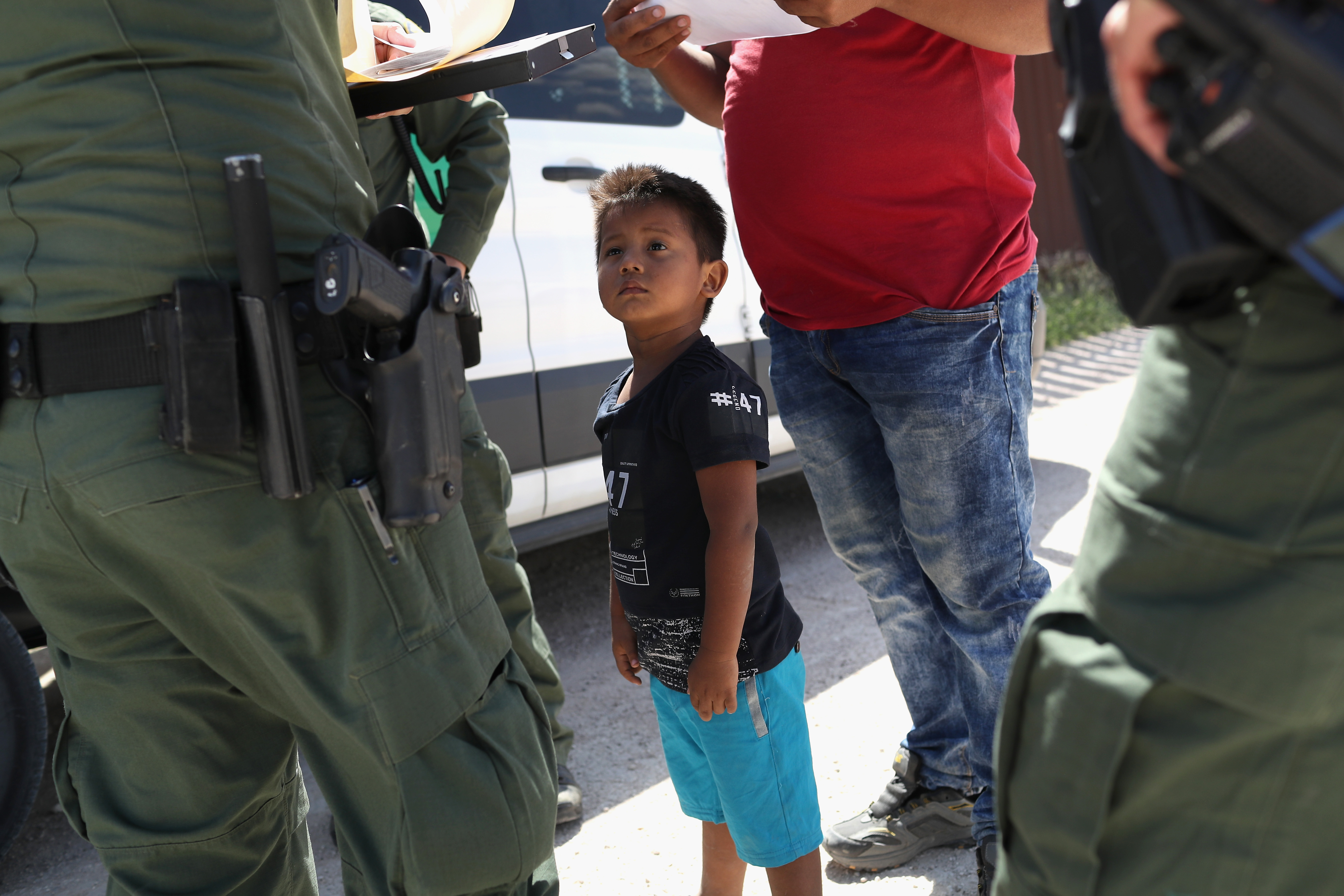 A boy and father from Honduras are taken into custody by U.S. Border Patrol agents near the U.S.-Mexico Border on June 12, 2018 near Mission, Texas.