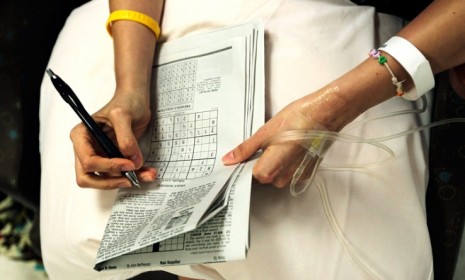 A cancer patient works on a puzzle as she gets chemotherapy treatment in North Carolina: According to a new study, chemotherapy can cause good cells to actually promote the growth of tumors.