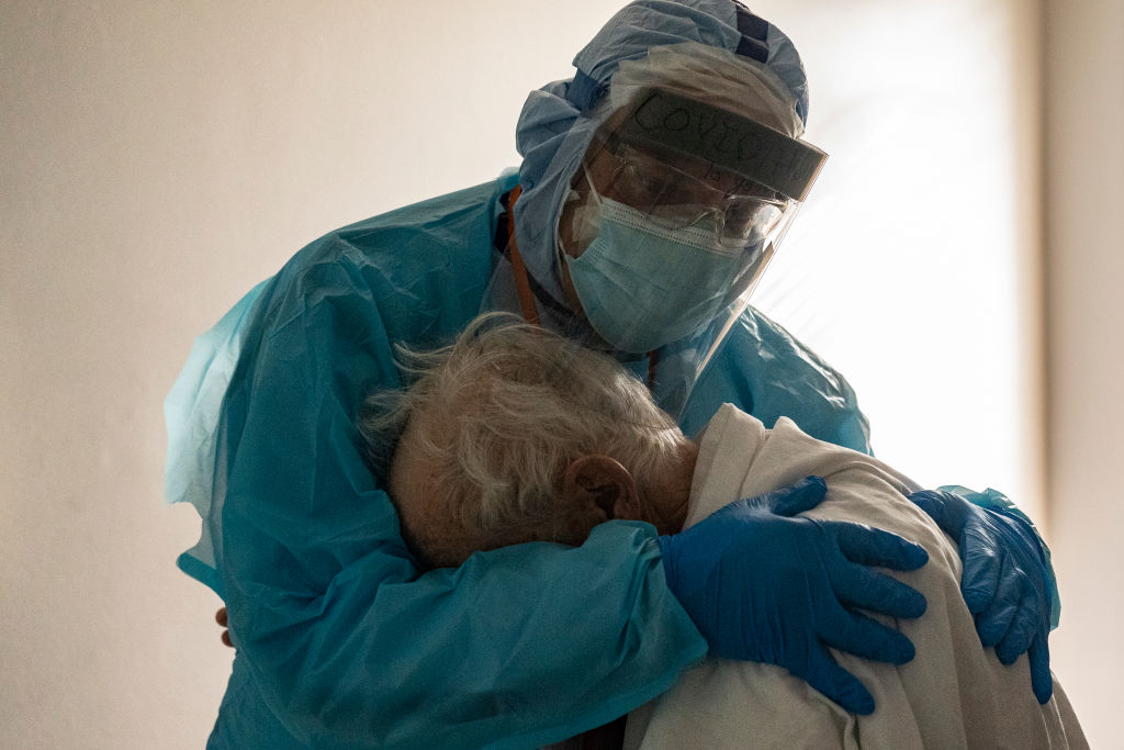 A health care worker comforts a patient.