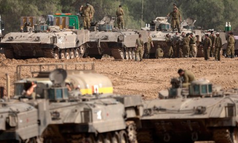 Israeli soldiers work on their tanks near the Gaza Strip, after fierce clashes with Gaza militants on Nov. 16.