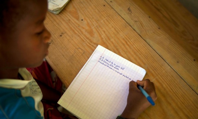A boy takes notes during a Creole class at the Louverture Cleary School in Haiti, Jan. 24.