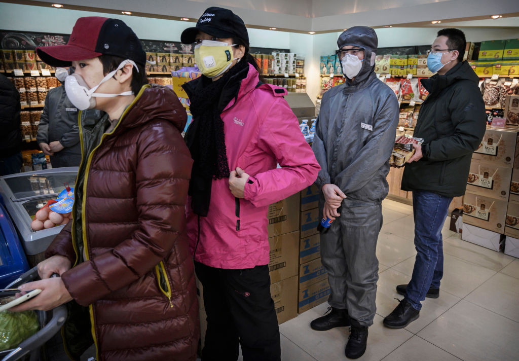 People in Beijing wear masks while waiting in line at the grocery store.