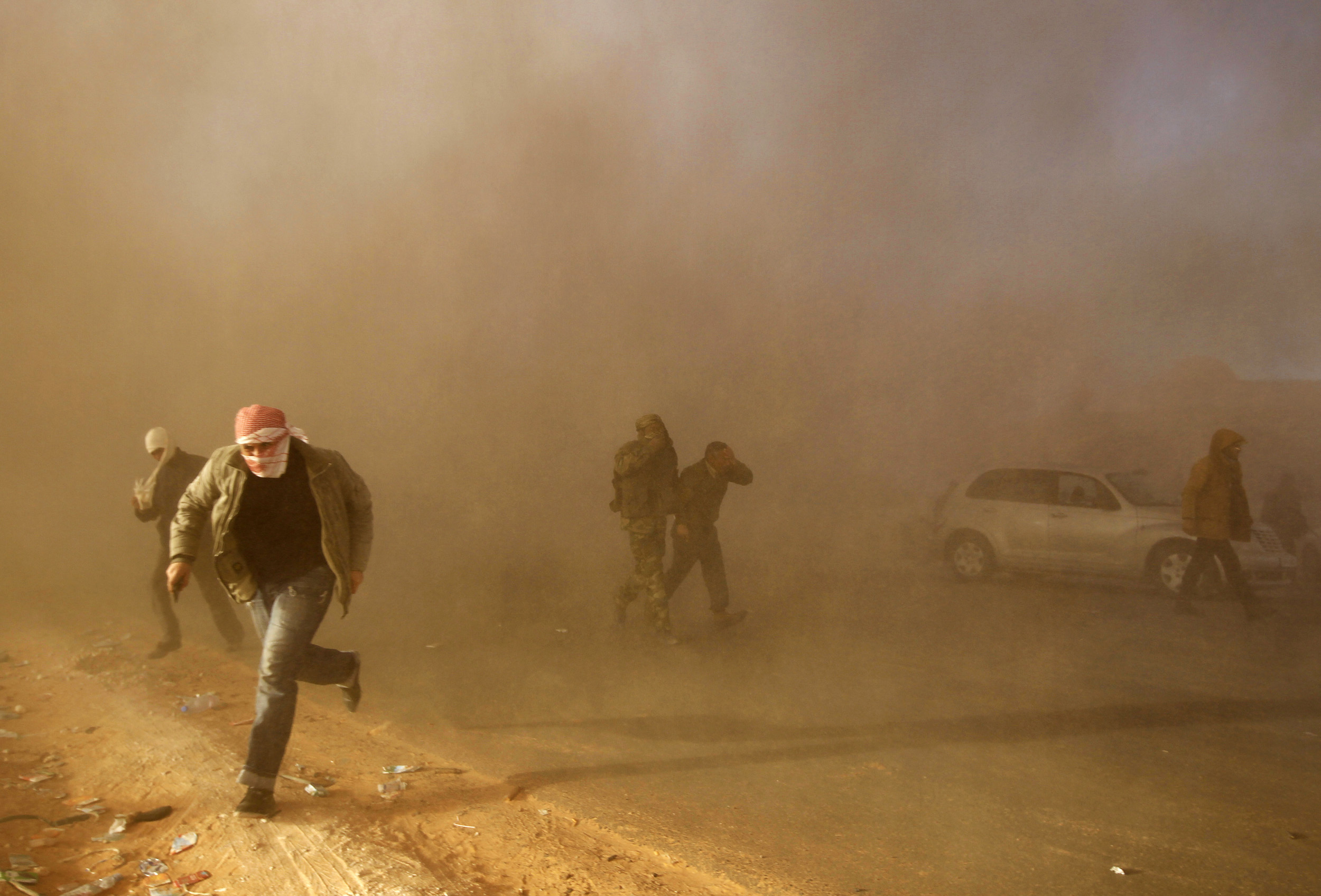 Libyan rebel fighters run for cover in 2011.