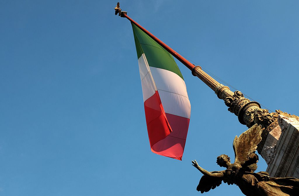 The Italian flag flies over a monument in Rome
