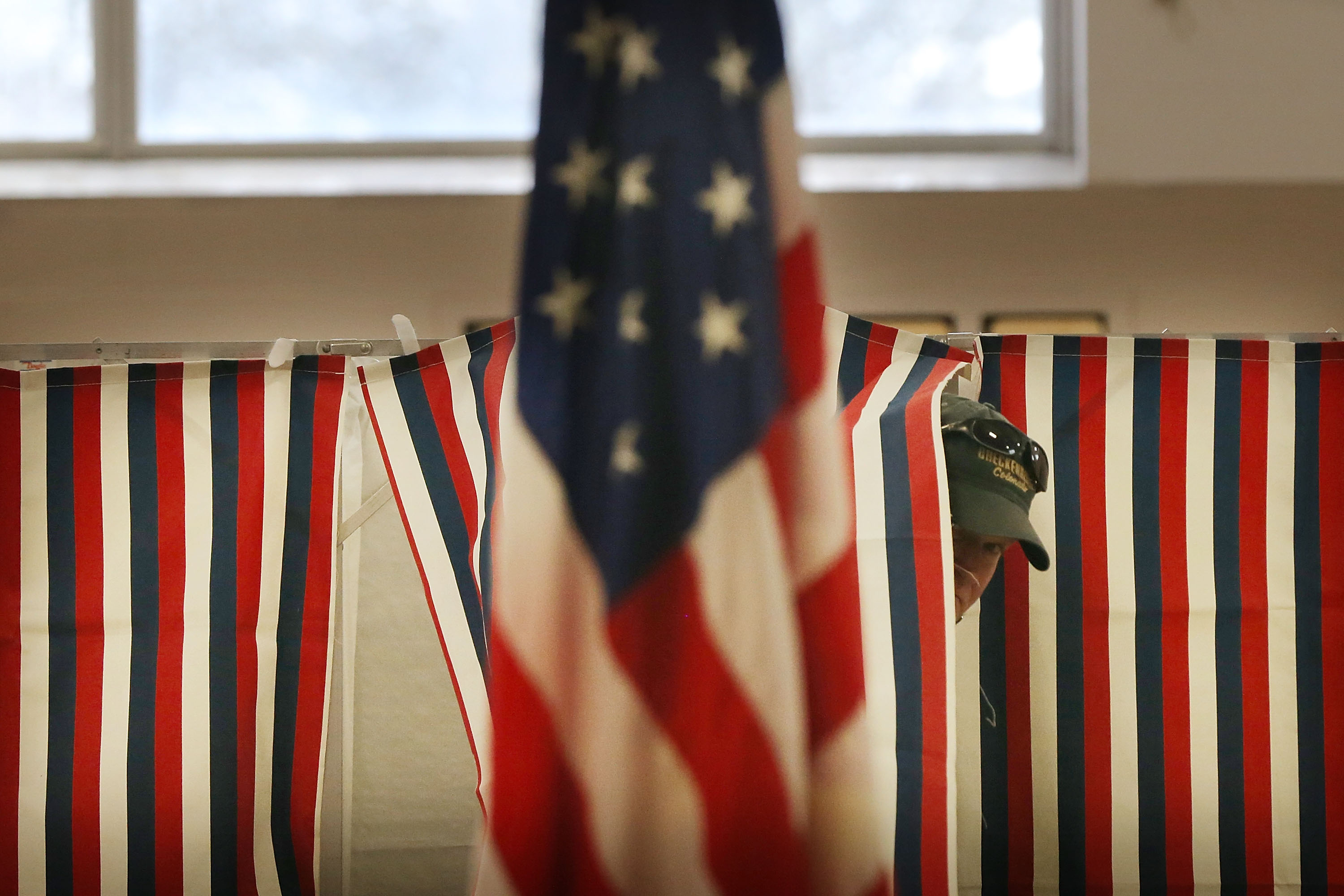 A New Hampshire man exits a voting booth during the presidential primaries.