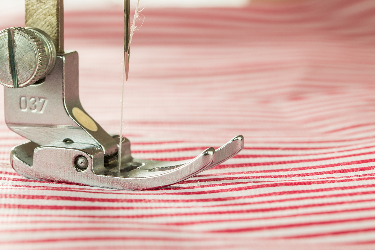 A close up of a sewing machine and fabric.