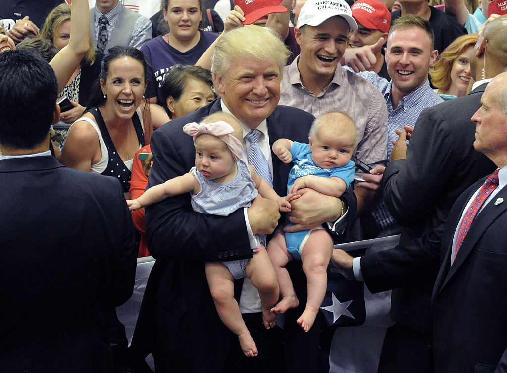 Donald Trump, holding babies, has reportedly never changed a diaper