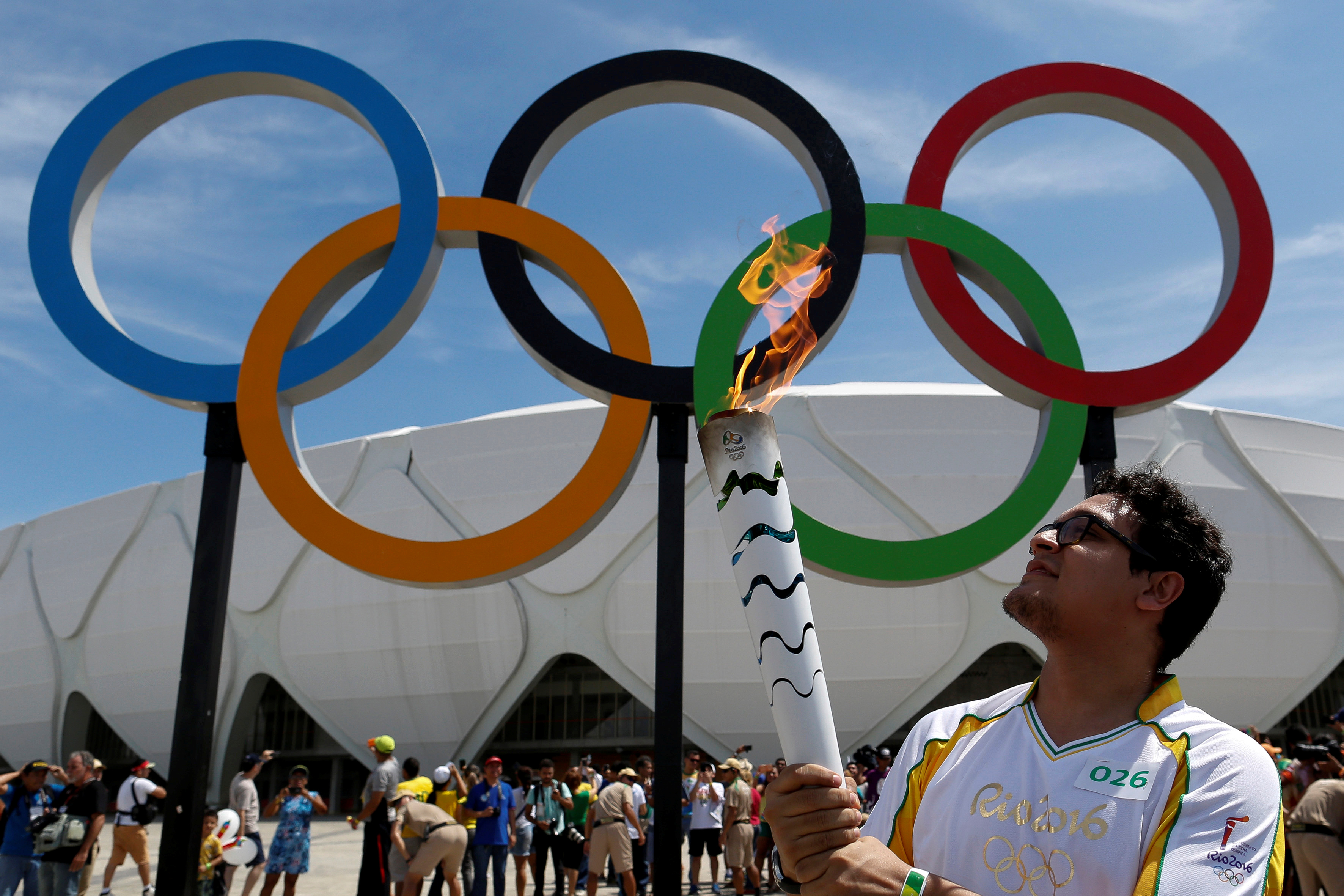 Brazilian designer Glauber Penha takes part in the Olympic Flame torch relay.