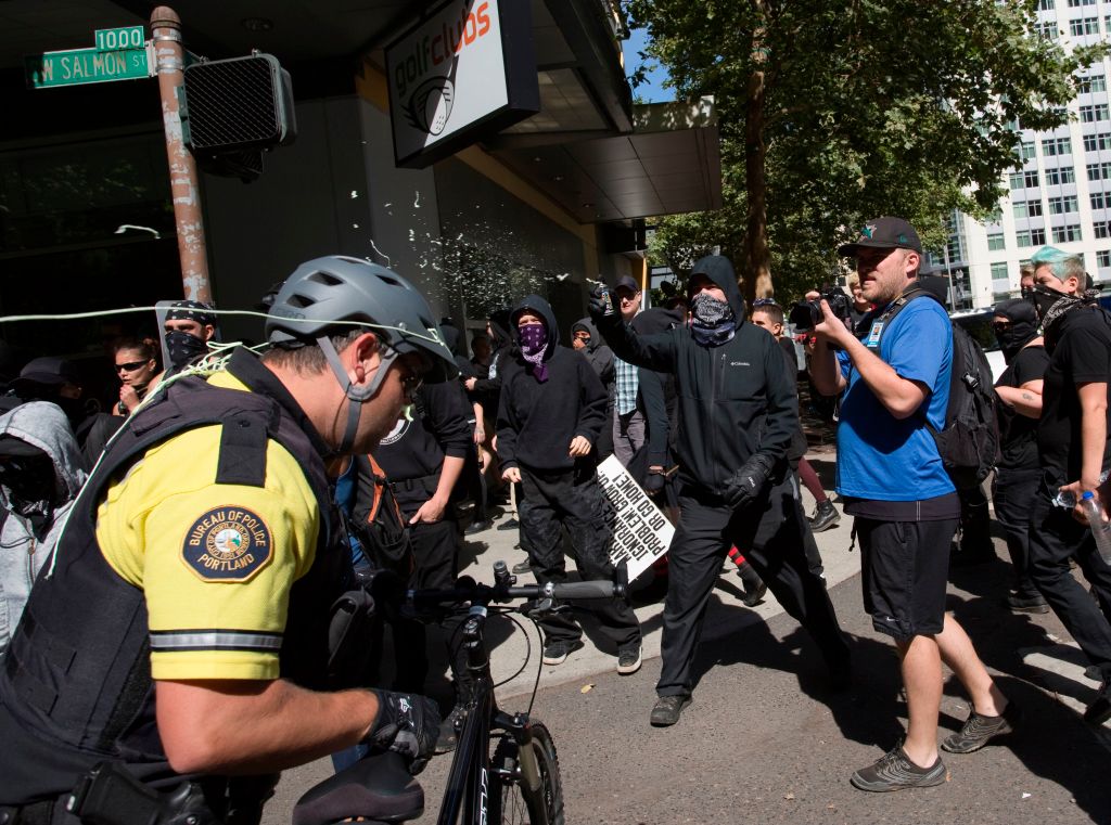 Antifa spray silly string at police during a protest in Portland, Oregon.