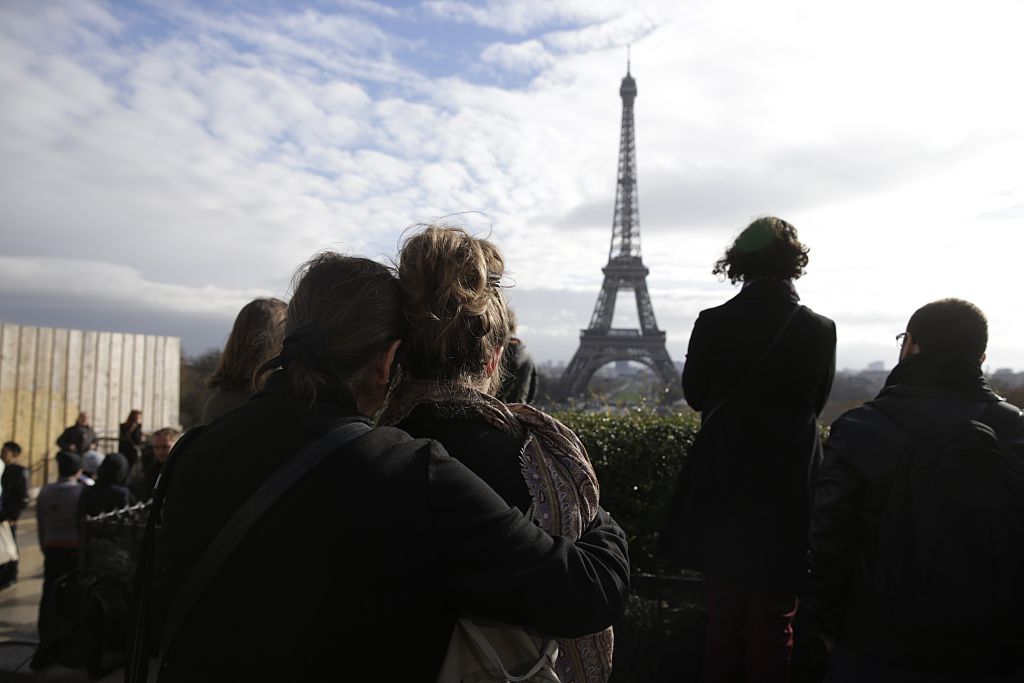 People observe a minute of silence at the Place de Trocadero in Paris on November 16, 2015