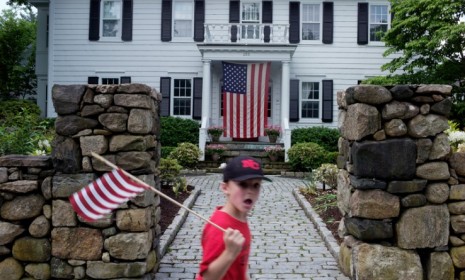 A boy waves a flag during the annual Memorial Day Parade in New Canaan, Conn., one of the wealthiest communities in the U.S.: According to a new report, the median family income dropped 8 per