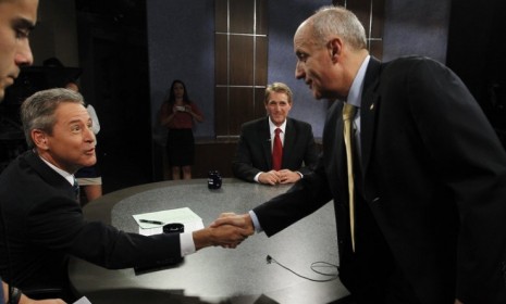 Rep. Jeff Flake (R-Ariz.) looks on as Richard Carmona, right, shakes hands with moderator Ted Simons before an Arizona Senate debate on Oct. 10: Flake looked to have an easy victory ahead of 