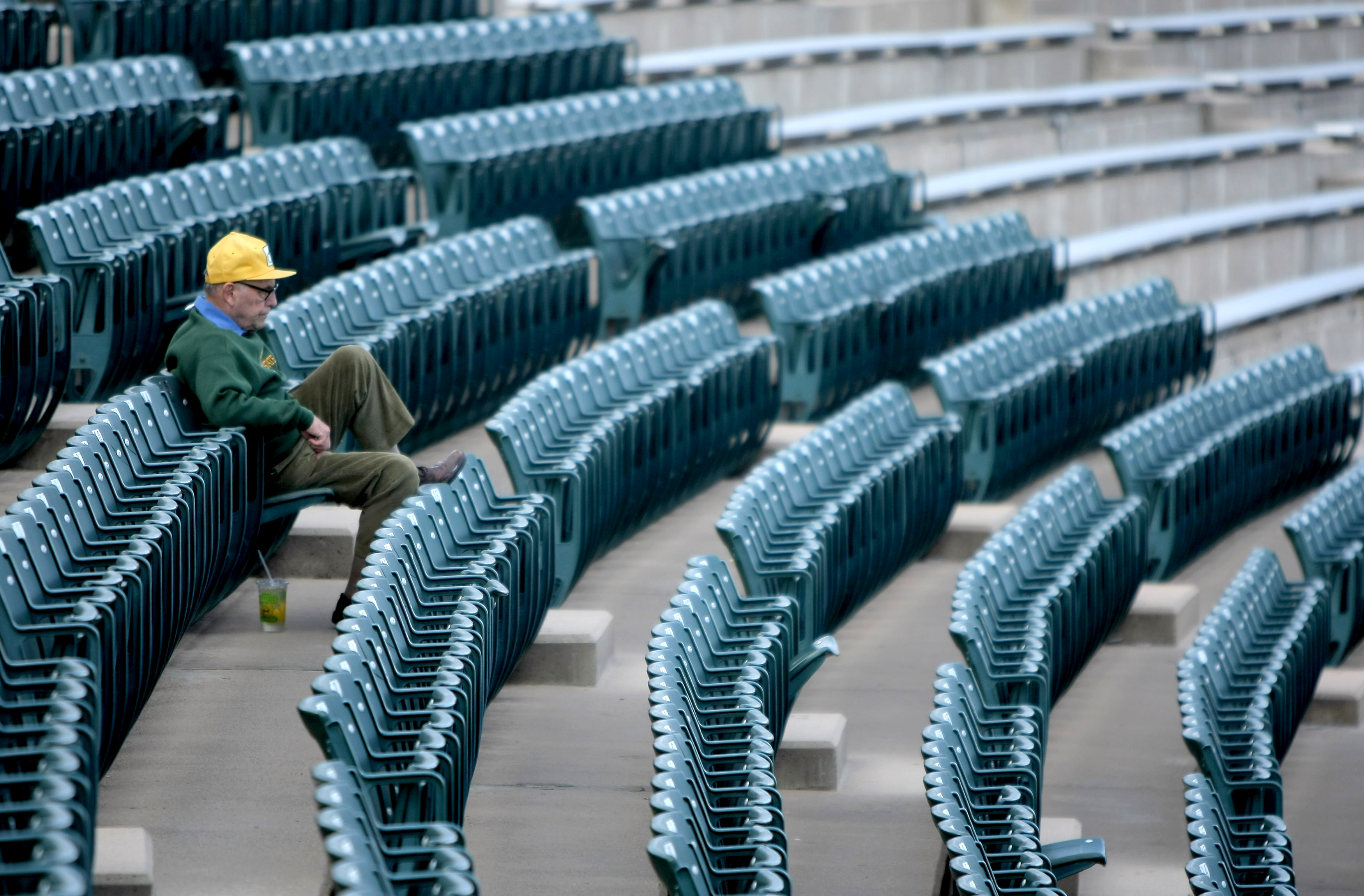 An old man sits alone in a stadium because there aren&#039;t enough American people to fill it or our jobs