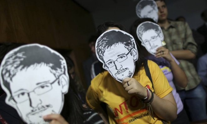 People wear Edward Snowden masks during Glenn Greenwald&#039;s testimony before a Brazilian congressional committee on Aug. 6.