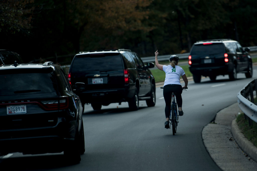 A woman flips off Trump in his motorcade.