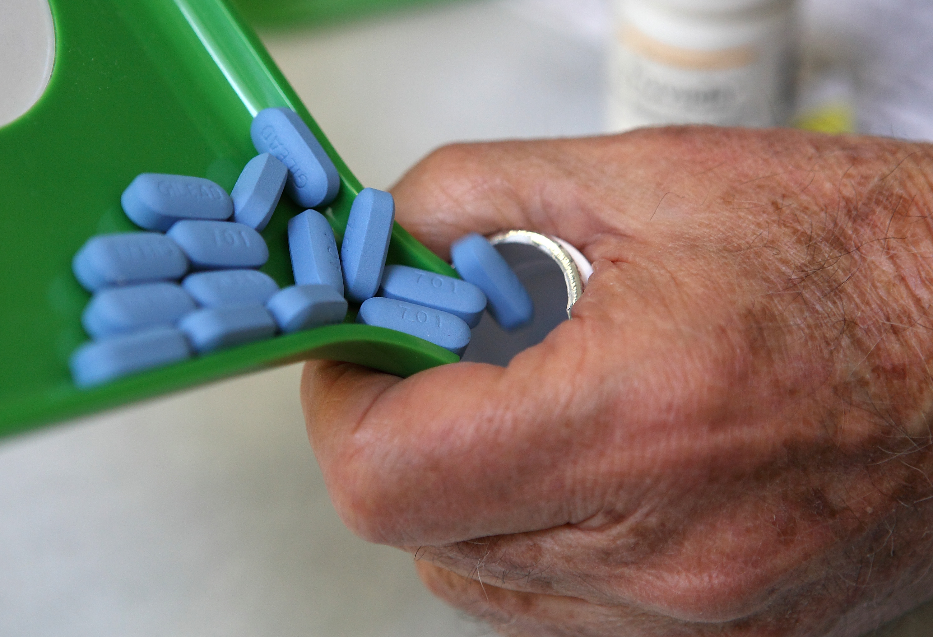 Pharmacist pours Truvada pills into a bottle.