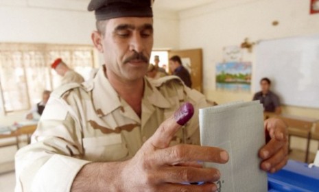 An Iraqi soldier votes in an election.