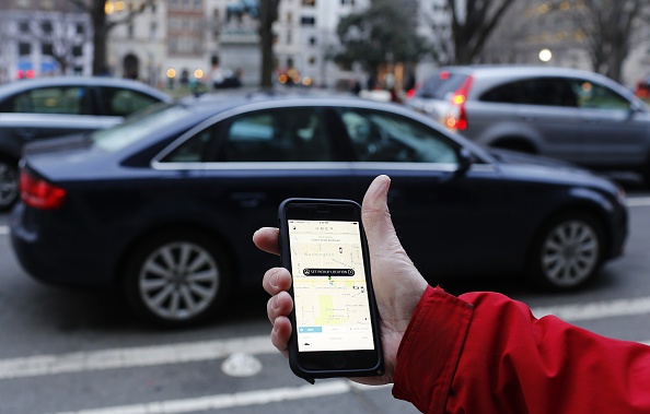 A person uses a ride-sharing app to hail a car.