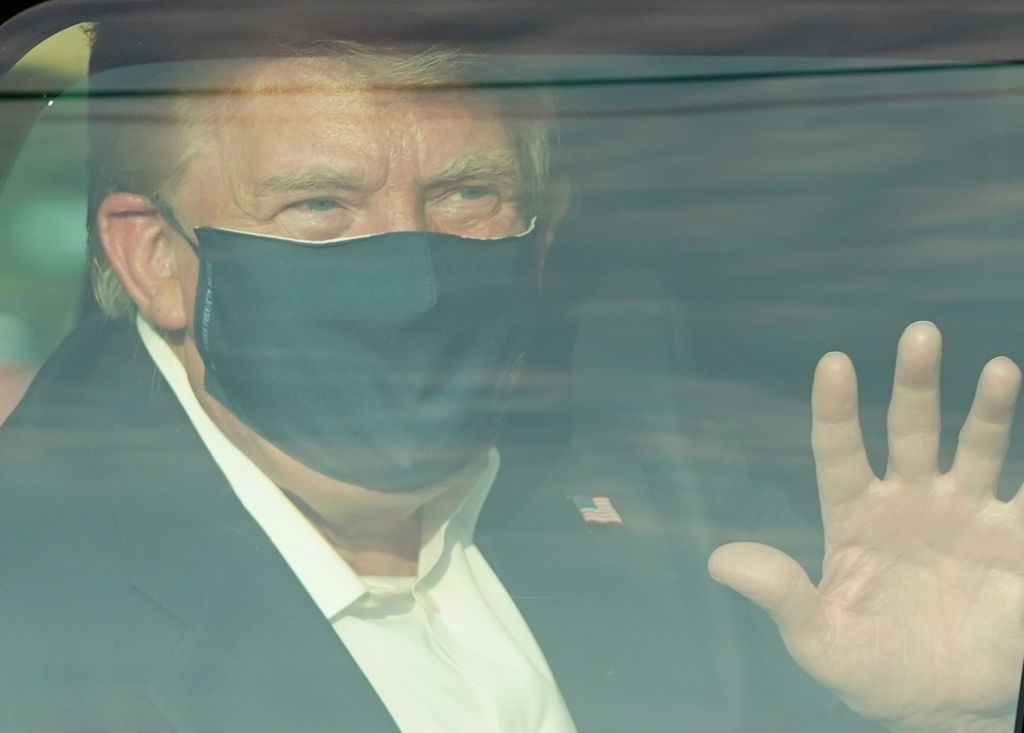 Donald Trump waves from his motorcade.